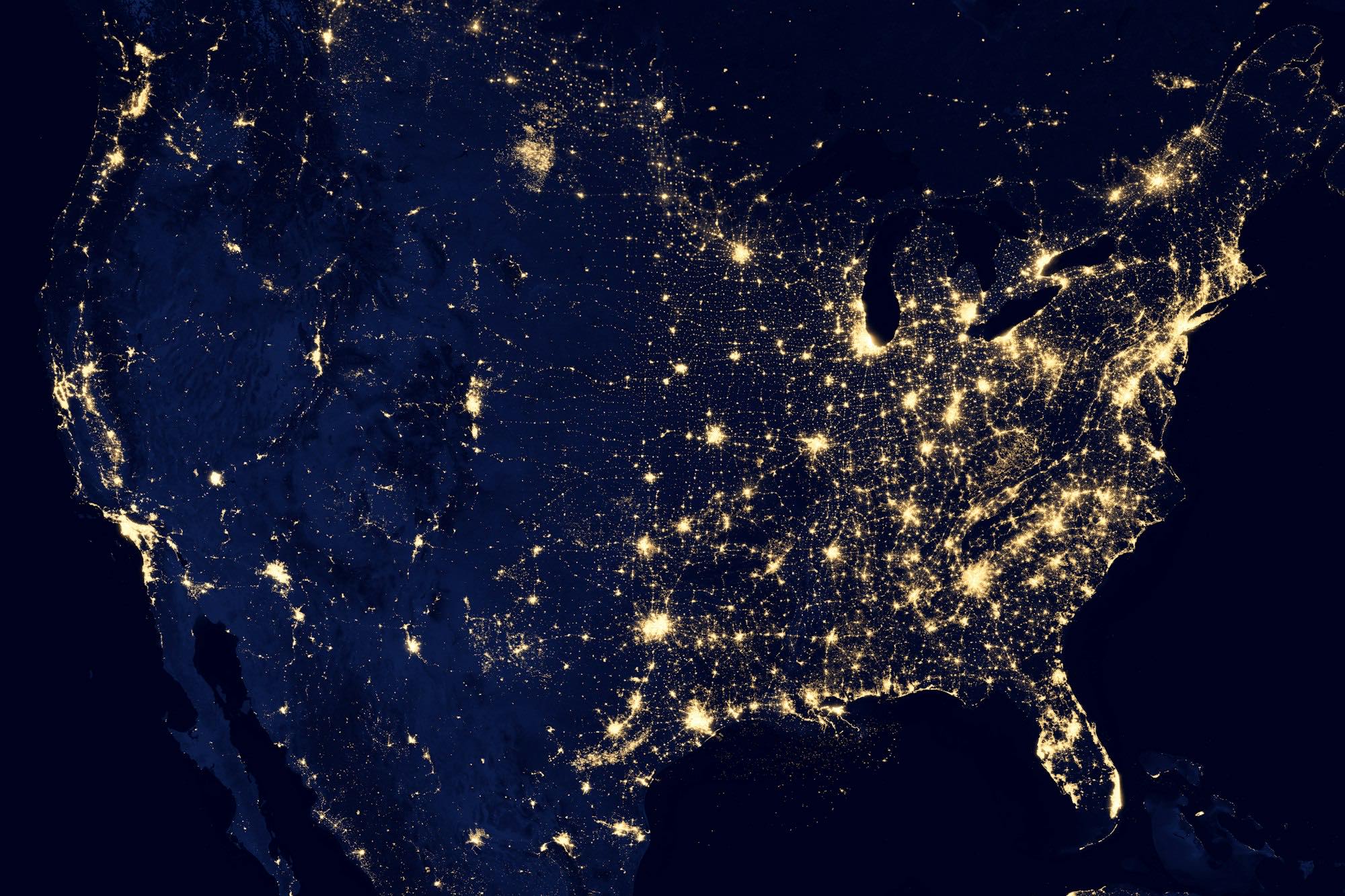 Satellite view of city lights glowing across a continent at night